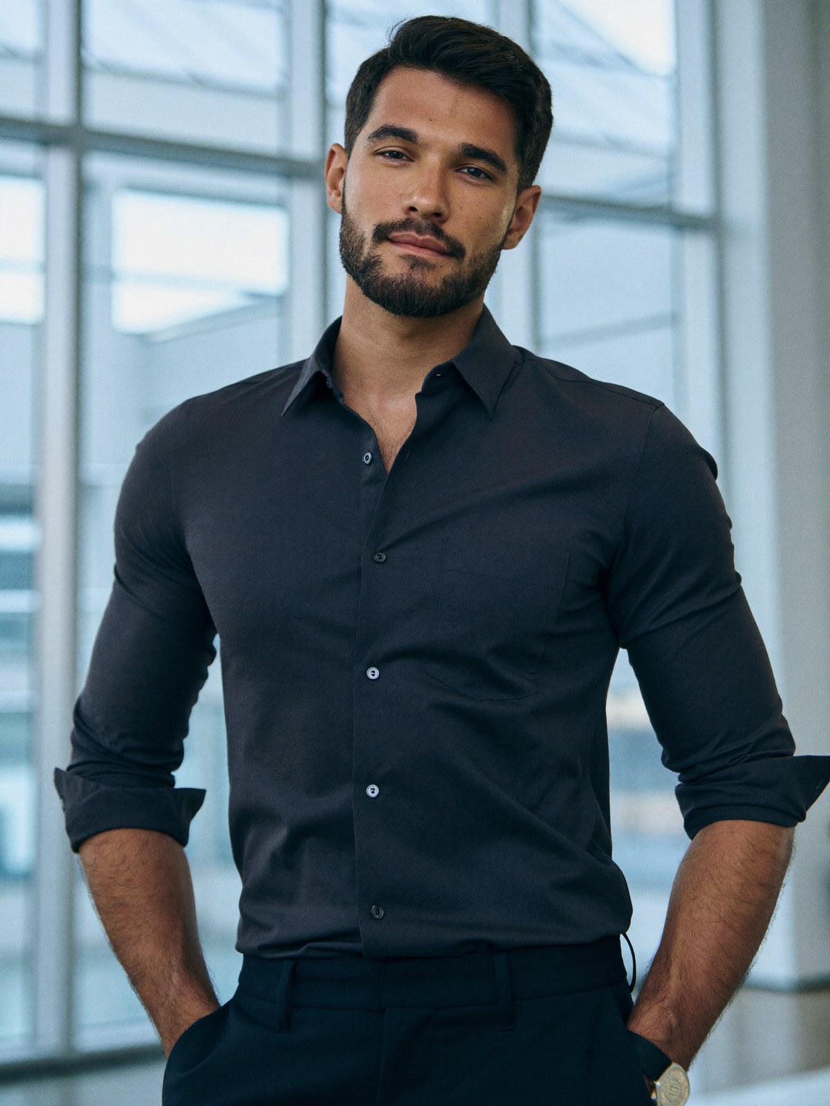 A composed, confident man at ease in a bright, modern clinical space, fully dressed