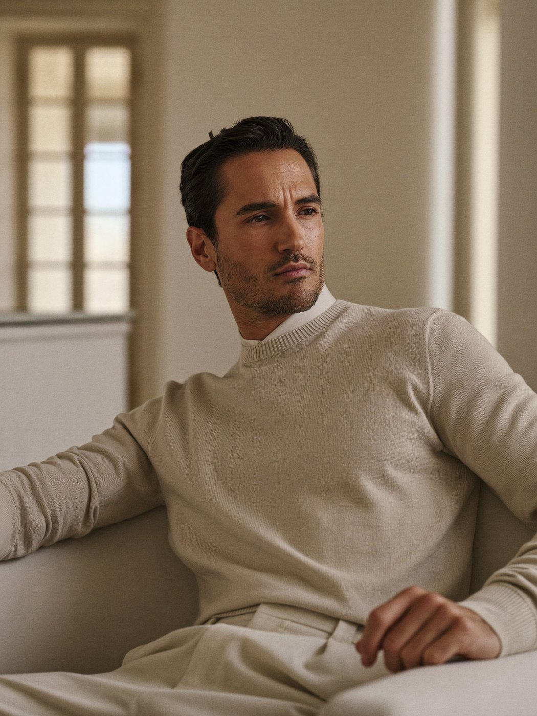 A composed, confident man at ease in a quiet, refined interior