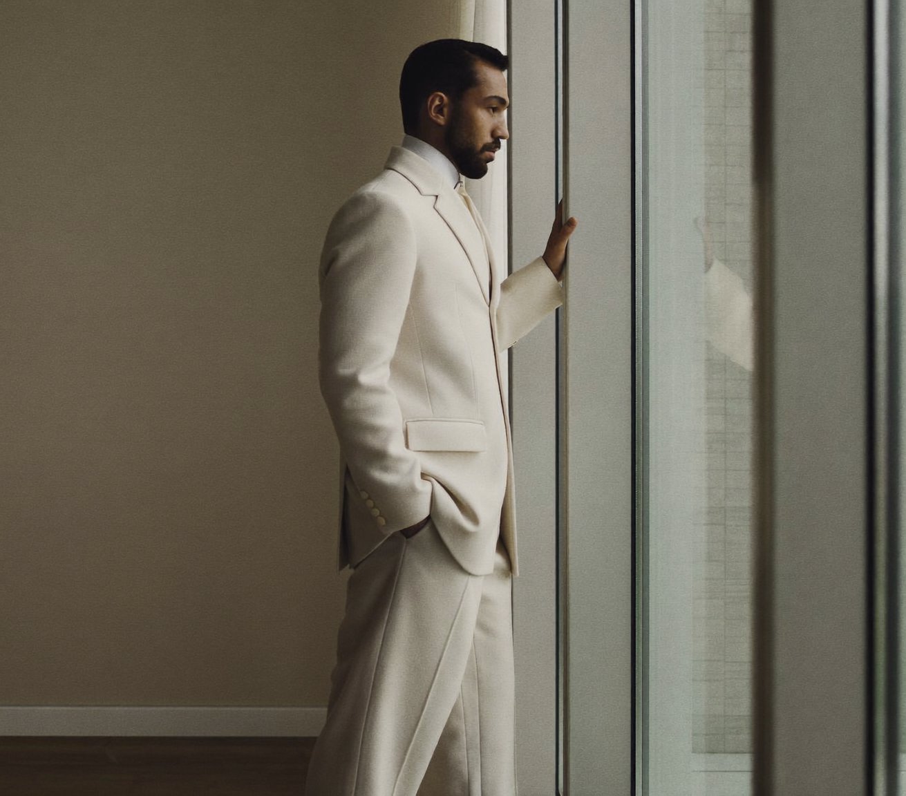 A composed man at a window, calm and at ease